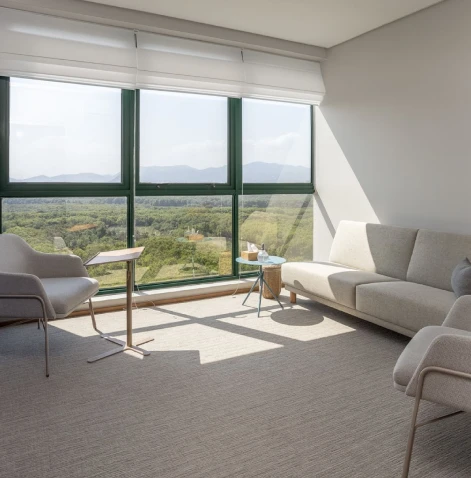 Profissional sorrindo durante videochamada exibida em notebook sobre a mesa.