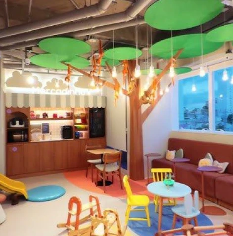 Profissional sorrindo durante videochamada exibida em notebook sobre a mesa.